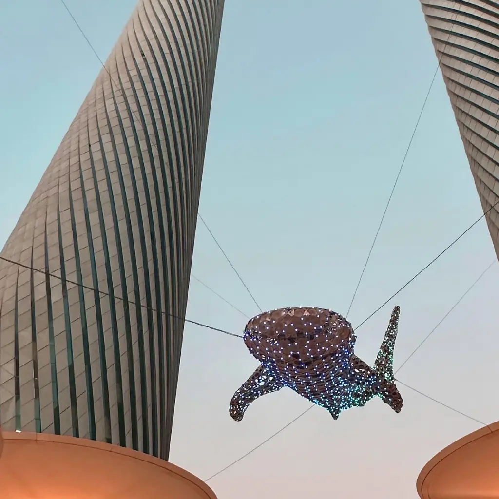 Doha in Katar, eine mit Lichtern geschmückte Walhai-Skulptur wird durch Stahlseile in der Luft gehalten