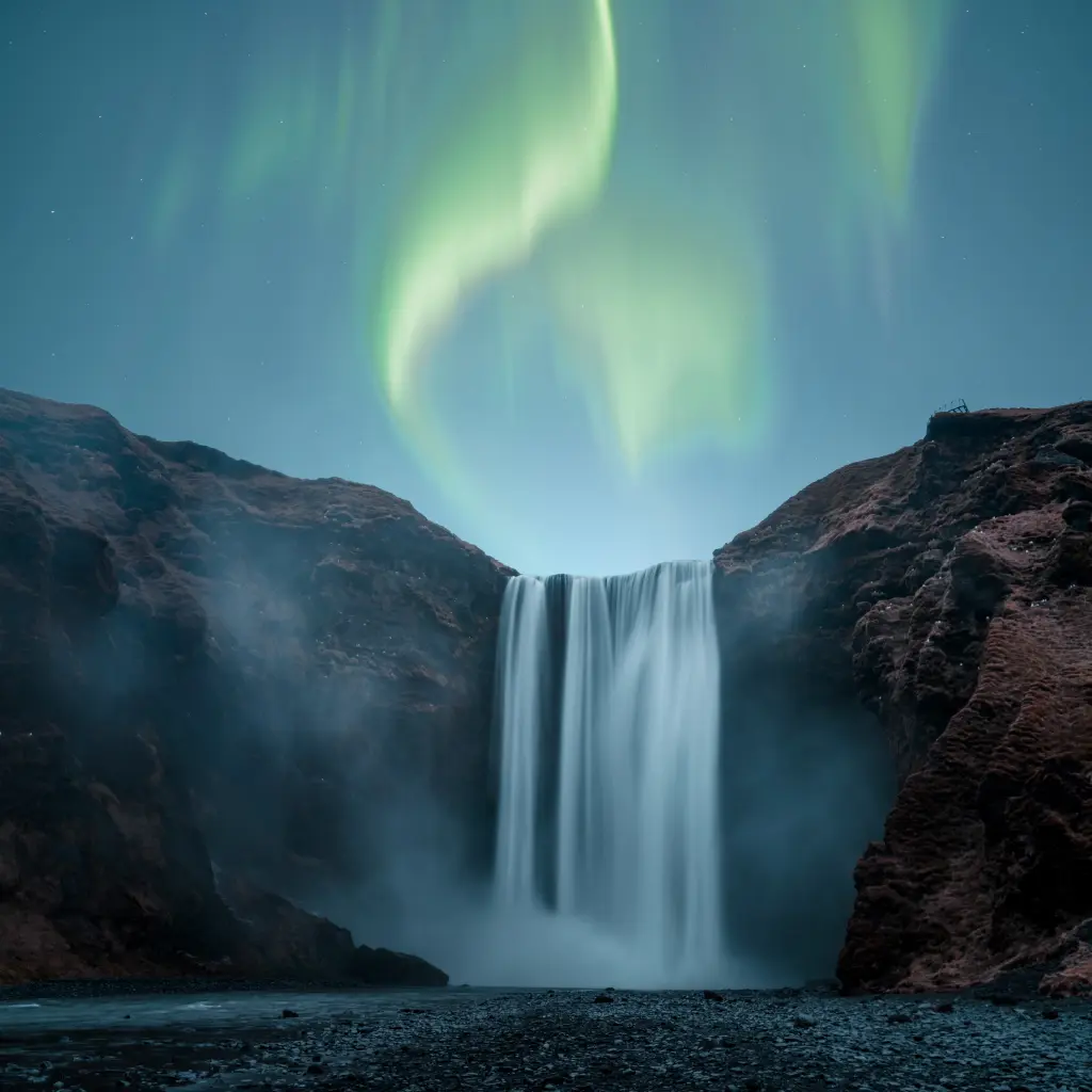 Skógafoss in Island, Polarlichter über einem Wasserfall bei Nacht